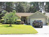 Charming single-story home featuring a well-manicured lawn, mature trees, and a two-car garage at 1307 Carolina Wren Ln., Murrells Inlet, SC 29576