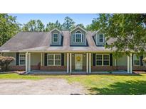 Charming home featuring a welcoming front porch with white columns and black shutters, set against a lush green lawn at 140 Pixie Dust Ct., Myrtle Beach, SC 29588