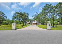 Beautiful two-story home with a long drive, lush lawn, and mature trees at 2192 Eastwoods Dr., Conway, SC 29526