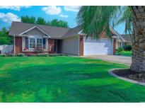 Charming single-story home with a manicured lawn and a two-car garage, complemented by vibrant flower beds at 2479 Burning Tree Ln., Little River, SC 29566