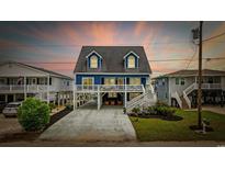 Charming stilted home with a spacious driveway, elevated deck, and lovely architectural details at 302 46Th Ave. N, North Myrtle Beach, SC 29582