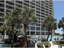 Beautiful outdoor pool area with palm trees and views of the condo building at 4800 S Ocean Blvd. # 706, North Myrtle Beach, SC 29582