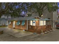 Charming exterior with wood siding, turquoise shutters and a spacious wood deck with blue umbrellas at 6001 - 1040 S Kings Hwy., Myrtle Beach, SC 29575