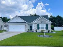 Charming single-story home with stone accents, lush lawn, and attached two-car garage at 620 Bathurst Dr., Myrtle Beach, SC 29579