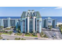 Stunning exterior shot of an ocean-front resort with blue facade, balconies, and immaculate landscaping at 6804 North Ocean Blvd. # 515, Myrtle Beach, SC 29572