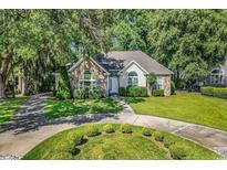 Charming home with stone facade, lush landscaping, and a circular driveway at 765 Shaftesbury Ln., Conway, SC 29526
