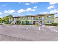 Multi-unit building featuring light green facade, white staircases, and ample parking space at 1301 Pridgen Rd. # 903, Myrtle Beach, SC 29577