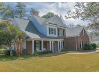 Charming two-story brick home featuring a welcoming front porch and well-manicured lawn at 1427 Mcmaster Dr., Myrtle Beach, SC 29575
