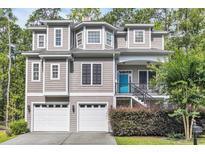 Charming home with gray siding, a blue front door, and a two-car garage, nestled among lush trees at 154 Harbor Oaks Dr., Myrtle Beach, SC 29588