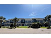 View of the exterior of the condo building with lush green landscaping at 1851 Colony Dr. # 5M, Surfside Beach, SC 29575