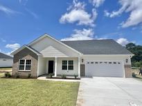 Charming single-story home featuring a brick and white exterior, a two-car garage, and a well-manicured lawn at 197 Norris Ln, Loris, SC 29569