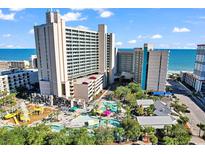 Aerial view showcases the resort's pool area, water park, and oceanfront location on a sunny day at 205 74Th Ave. N # 1607, Myrtle Beach, SC 29577
