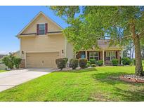 Charming home exterior featuring a well-manicured lawn, an attached garage, and stone accents at 221 Rivers Edge Dr., Conway, SC 29526