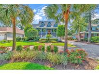 Charming two-story home with a manicured front yard, lush landscaping, and beautiful curb appeal framed by palm trees at 315 14Th Ave. N, Surfside Beach, SC 29575