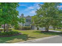 Charming two-story home with well-manicured lawn, lush landscaping, and attached garage at 4539 Fringetree Dr., Murrells Inlet, SC 29576