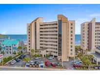 Multi-story condo building features a parking lot, neutral tones, and coastal views at 517 S Ocean Blvd. # 705, North Myrtle Beach, SC 29582