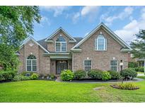 Charming brick home featuring a well-manicured lawn, mature landscaping, and beautiful curb appeal at 8013 Wacobee Dr., Myrtle Beach, SC 29579