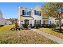 Charming two-story home with an American flag displayed and lush landscaping at 864 Barn Owl Ct. # 864, Myrtle Beach, SC 29579