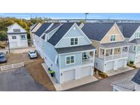 Charming two-story coastal home featuring a balcony, double garage, and stylish light blue siding at 146 Marblehead Dr., Little River, SC 29566