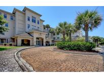 Beautiful building exterior showcasing a circular brick driveway and lush palm trees at 2180 Waterview Dr. # 721, North Myrtle Beach, SC 29582