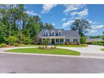Charming home with a well-manicured lawn, circular driveway, and inviting front porch at 226 Red Tail Hawk Loop, Pawleys Island, SC 29585