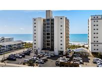 Beachfront condo building featuring a parking area and partial ocean view at 2501 S Ocean Blvd. # 508, North Myrtle Beach, SC 29582