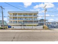 Charming condo complex with multiple balconies, white railings, and inviting curb appeal at 301 N Waccamaw Dr. # 311, Garden City Beach, SC 29576
