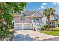 Charming two-story home features a two-car garage and a staircase leading to the front porch entry at 4490 Barcelona Ln., Little River, SC 29566