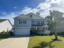 Charming two-story home with a manicured lawn, inviting curb appeal, and an attached two-car garage at 454 Pacific Commons Dr., Surfside Beach, SC 29575