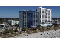 Expansive beachfront view of tall condominium complex overlooking sandy beach with blue skies at 504 Ocean Blvd. N # 410, Myrtle Beach, SC 29577