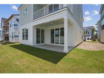 Covered patio with white columns leads out to a lush green yard through sliding glass doors at 512 9Th Ave. S, North Myrtle Beach, SC 29582