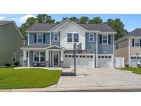 Beautiful two-story home featuring blue siding, white trim, a three-car garage, and a well-maintained front yard at 6271 Chadderton Circle, Myrtle Beach, SC 29579