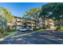 Well maintained condo building with mature landscaping, large shade tree, and ample parking at 9501 Shore Dr. # B-224, Myrtle Beach, SC 29572