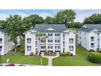 Inviting three-story condo featuring private balconies, lush landscaping, and sidewalks at 521 White River Dr. # 21C, Myrtle Beach, SC 29579