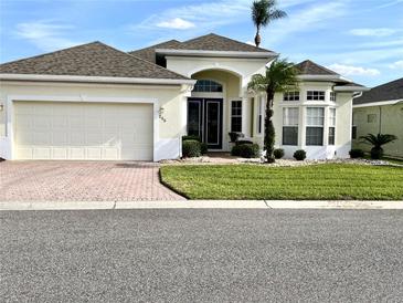 Charming single-story home with a two-car garage, manicured lawn, and beautiful tropical landscaping at 255 Royal Palm Dr, Davenport, FL 33837