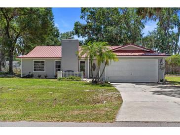 Charming single-story home boasts a red roof, two-car garage, and well-manicured front lawn at 3240 Flamingo Ln, Mulberry, FL 33860