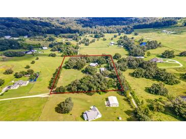 Expansive aerial view of the property, showing the large acreage with trees, green fields, and outlined property lines at 4292 Sw 73Rd Trl, Bushnell, FL 33513