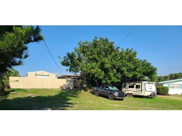 View of the property with a mature tree, an recreational vehicle, and a truck at 1505 N Peninsula Ave, New Smyrna Beach, FL 32169