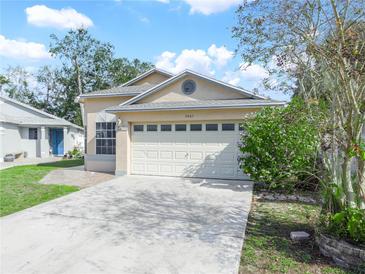 House exterior featuring a two-car garage and well-maintained lawn at 2907 Willow Oak Ct, Kissimmee, FL 34744
