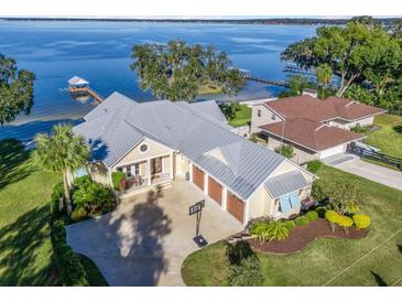 Waterfront home with expansive lake views, large yard, and three-car garage at 12943 Se Sunset Harbor Rd, Weirsdale, FL 32195