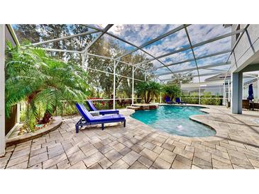 Relaxing pool area with patio furniture under a screened-in enclosure at 1457 Olympic Club Blvd, Champions Gate, FL 33896