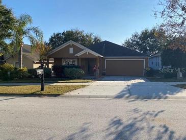 One-story house with attached garage and landscaped front yard at 124 Dakota Ave, Groveland, FL 34736