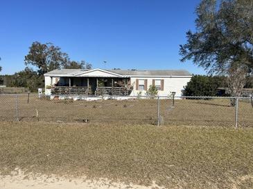 Single-wide manufactured home on a spacious lot with a chain link fence at 2725 Schreffler Rd, Groveland, FL 34736