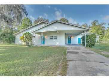 White house with teal doors, covered patio, and a large grassy yard at 270 N 1St St, Lake Mary, FL 32746