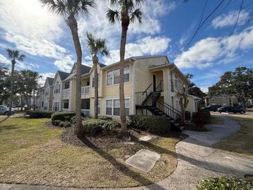 Two-story condo building with palm trees and walkway at 1031 S Hiawassee Rd # 2524, Orlando, FL 32835