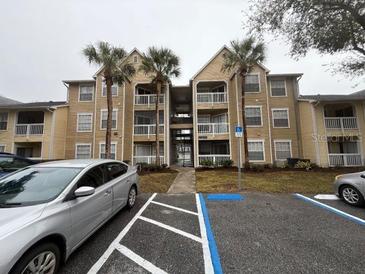 Condo building exterior with parking and landscaping at 1065 S Hiawassee Rd # 1416, Orlando, FL 32835