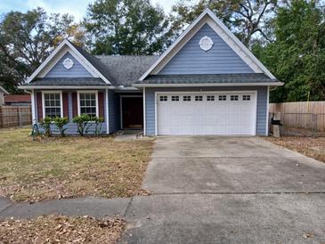 Cute blue house with a white garage door and a well-maintained lawn at 305 Pinecrest Rd, Mount Dora, FL 32757