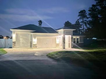 Attractive single-story home with a two-car garage and well-manicured lawn at night at 9805 Sw 44Th Ter, Ocala, FL 34476