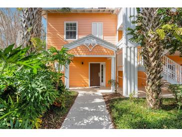 Inviting front entrance of a cheerful two-story home with well-maintained landscaping and a covered porch at 301 New Providence Promenade, Davenport, FL 33897