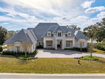 Grand home features a manicured lawn, elegant entrance, and circular brick driveway at 8570 Nw 31St Lane Rd, Ocala, FL 34482